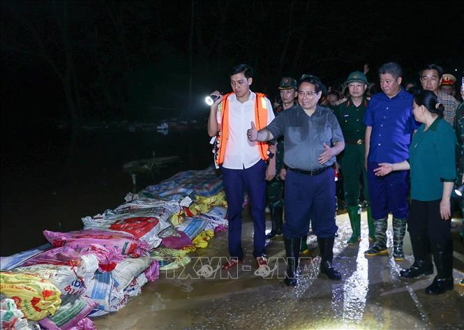 Thủ tướng Phạm Minh Chính chỉ đạo phòng chống lũ, ứng cứu sự cố, bảo đảm an toàn tuyến đê hữu Cầu. Ảnh: Dương Giang-TTXVN