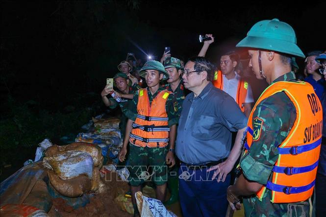 Thủ tướng Phạm Minh Chính chỉ đạo phòng chống lũ, ứng cứu sự cố, bảo đảm an toàn tuyến đê hữu Cầu. Ảnh: Dương Giang-TTXVN