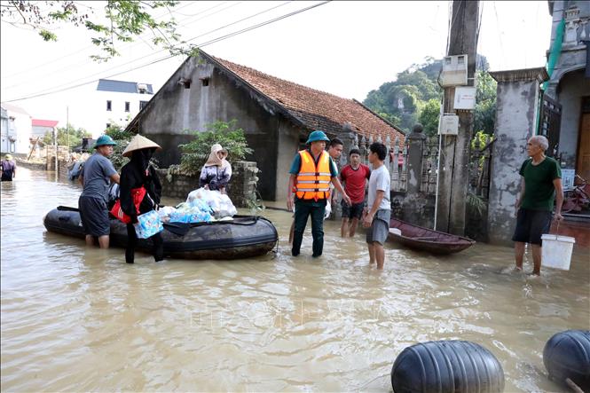 Lực lượng quân sự xã Vân Nham, tỉnh Lạng Sơn cùng đoàn cứu trợ tiếp tế nhu yếu phẩm cho người dân. Ảnh: Văn Đạt - TTXVN