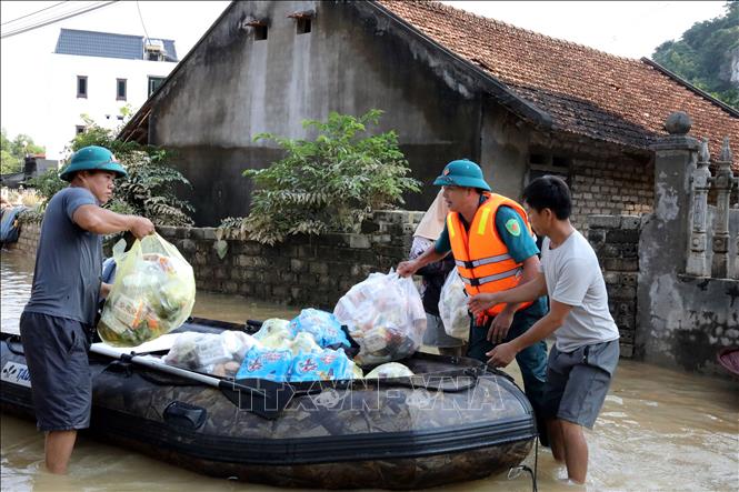 Lực lượng quân sự xã Vân Nham, tỉnh Lạng Sơn cùng đoàn cứu trợ tiếp tế nhu yếu phẩm cho nhân dân. Ảnh: Văn Đạt - TTXVN