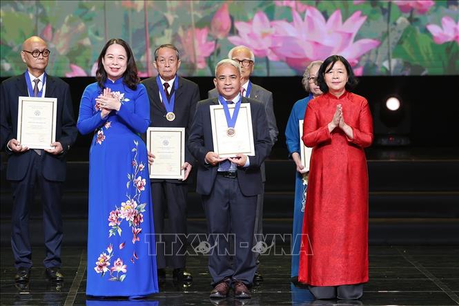 Phó Chủ tịch nước Võ Thị Ánh Xuân, Phó Chủ tịch thứ nhất Hội đồng Thi đua-Khen thưởng Trung ương và Bí thư Thành ủy Hà Nội Bùi Thị Minh Hoài trao tặng danh hiệu Công dân Thủ đô ưu tú năm 2025 cho Nghệ nhân nhân dân Nguyễn Văn Tĩnh, Hội mây tre Phú Nghĩa, Hiệp hội Thủ công mỹ nghệ và làng nghề Hà Nội. Ảnh: Dương Giang-TTXVN 
