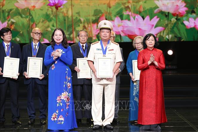 Phó Chủ tịch nước Võ Thị Ánh Xuân, Phó Chủ tịch thứ nhất Hội đồng Thi đua-Khen thưởng Trung ương và Bí thư Thành ủy Hà Nội Bùi Thị Minh Hoài trao tặng danh hiệu Công dân Thủ đô ưu tú năm 2025 cho Đại tá Đặng Việt Quảng, Trưởng phòng, phòng Cảnh sát điều tra tội phạm về Trật tự xã hội, Công an thành phố Hà Nội. Ảnh: Dương Giang-TTXVN 
