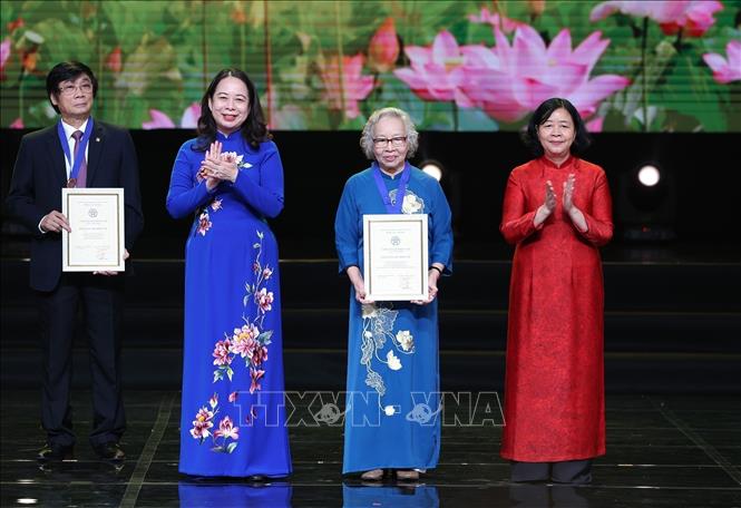 Phó Chủ tịch nước Võ Thị Ánh Xuân, Phó Chủ tịch thứ nhất Hội đồng Thi đua-Khen thưởng Trung ương và Bí thư Thành ủy Hà Nội Bùi Thị Minh Hoài trao tặng danh hiệu Công dân Thủ đô ưu tú năm 2025 cho Phó Giáo sư, Tiến sĩ, Bác sĩ cao cấp, Thầy thuốc nhân dân, Đại tá Nguyễn Kim Nữ Hiếu, nguyên Phó Giám đốc Bệnh viện Trung ương Quân đội 108. Ảnh: Dương Giang-TTXVN 
