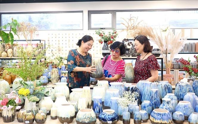 Nghệ nhân Hà Thị Vinh (ngoài cùng, bên trái), Chủ tịch Hiệp hội Thủ công mỹ nghệ và Làng nghề Hà Nội, Giám đốc Công ty TNHH Gốm sứ Quang Vinh với hơn 30 năm sản xuất gốm sứ mỹ nghệ phục vụ xuất khẩu - sản phẩm OCOP 5 sao cấp quốc gia, đưa sản phẩm bước vào thị trường châu Âu. Hiện công ty có trên 700 lao động hoạt động tại 2 cơ sở Bát Tràng và Quảng Ninh, công ty Quang Vinh trở thành cái tên sáng trong làng gốm sứ Việt. Ảnh: Phương Hoa - TTXVN