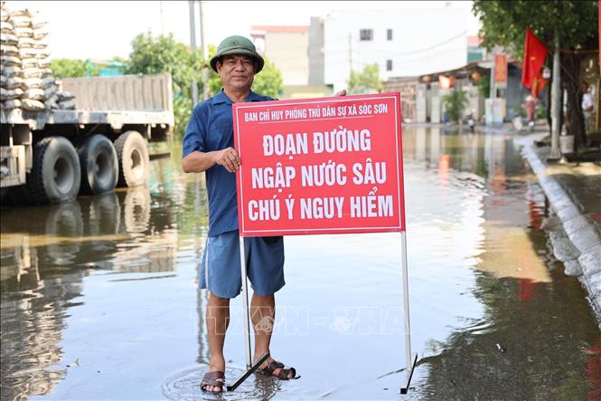 Các đơn vị chức năng khẩn trương có mặt tại Quốc lộ 16 hướng dẫn các phương tiện di chuyển an toàn, tránh khu vực ngập sâu. Ảnh: Vũ Quang - TTXVN