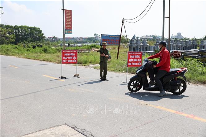 Lực lượng chức năng lập rào chắn và hướng dẫn người và phương tiện chuyển sang lộ trình khác nhằm đảm bảo an toàn. Ảnh: Vũ Quang - TTXVN
