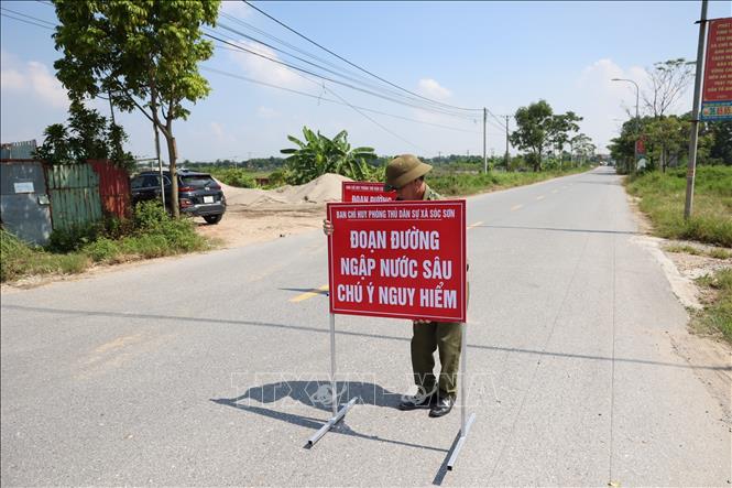 Các đơn vị chức năng địa phương khẩn trương có mặt tại Quốc lộ 16 để tổ chức phân luồng giao thông. Ảnh: Vũ Quang - TTXVN