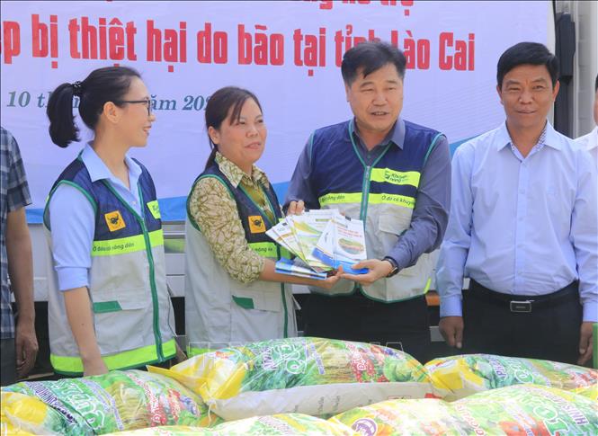 Giám đốc Trung tâm Khuyến nông Quốc gia Lê Quốc Thanh trao bộ tài liệu cho cán bộ khuyến nông cơ sở. Ảnh: Đinh Thùy - TTXVN