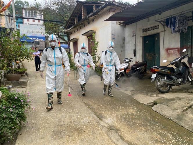 Cán bộ y tế phường Nùng Trí Cao phun khử trùng cho các khu dân cư sau khi nước rút. Ảnh: Quốc Đạt - TTXVN
