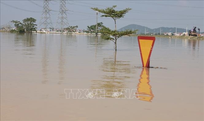 Những tuyến giao thông, biển báo chìm trong biển nước. Ảnh: Trần Việt - TTXVN 
