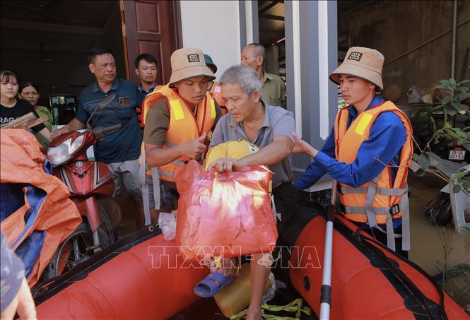 Lực lượng cứu hộ đưa người dân bệnh nặng đi cấp cứu. Ảnh: Phan Phương - TTXVN