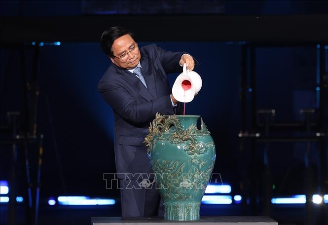 Thủ tướng Phạm Minh Chính thực hiện nghi thức vẽ tranh gốm ngũ sắc. Ảnh: Dương Giang-TTXVN 
