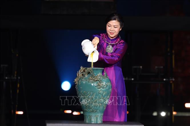 Bà Ngô Phương Ly, Phu nhân Tổng Bí thư Tô Lâm thực hiện nghi thức vẽ tranh gốm ngũ sắc. Ảnh: Dương Giang-TTXVN 