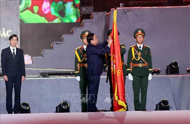 Phó Chủ tịch Quốc hội Lê Minh Hoan gắn Huân chương Lao động hạng Nhất lên cờ truyền thống của tỉnh Sơn La. Ảnh: Quang Quyết - TTXVN
