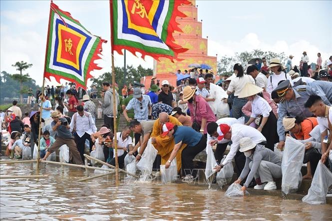 Đại biểu lãnh đạo thành phố cùng nhân dân địa phương và du khách tham gia thả cá tái tạo nguồn lợi thủy sản trên sông Lục Đầu. Ảnh: Mạnh Minh - TTXVN