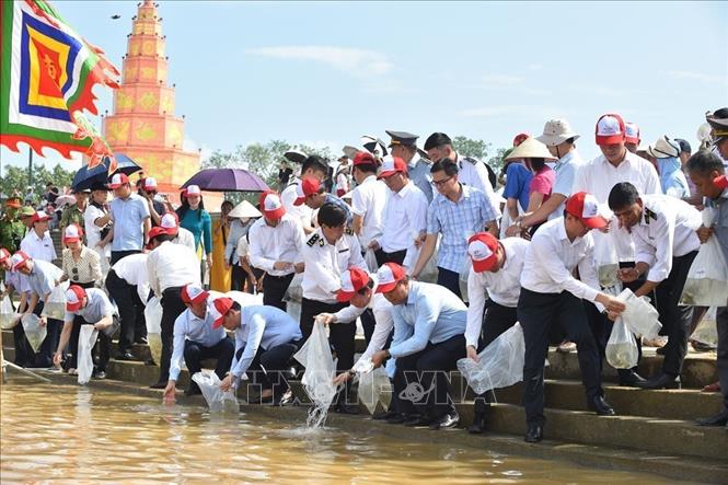 Đại biểu lãnh đạo và nhân dân tham gia thả cá tái tạo nguồn lợi thủy sản trên sông Lục Đầu. Ảnh: Mạnh Minh - TTXVN