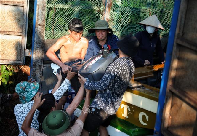 Vận chuyển nhu yếu phẩm đến với người dân. Ảnh: Danh Lam -TTXVN 