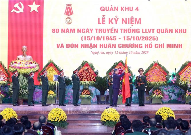 Tổng Bí thư Tô Lâm gắn Huân chương Hồ Chí Minh lên Cờ truyền thống của Quân khu 4. Ảnh: Thống Nhất-TTXVN