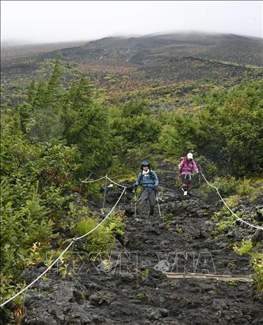 Du khách leo núi Phú Sĩ dọc tuyến đường Fujinomiya ở tỉnh Shizuoka, Nhật Bản. Ảnh: Kyodo/TTXVN