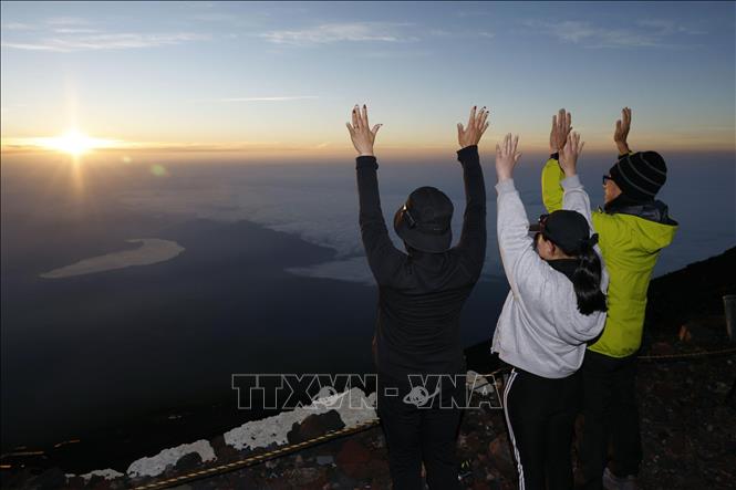Du khách ngắm bình minh trên đỉnh núi Phú Sĩ, Nhật Bản. Ảnh: Kyodo/TTXVN
