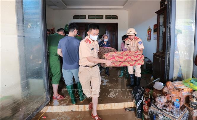 Lực lượng Công an giúp người dân vận chuyển đồ đạc tại thôn Nỷ, xã Trung Giã, Hà Nội. Ảnh: Lê Đông - TTXVN