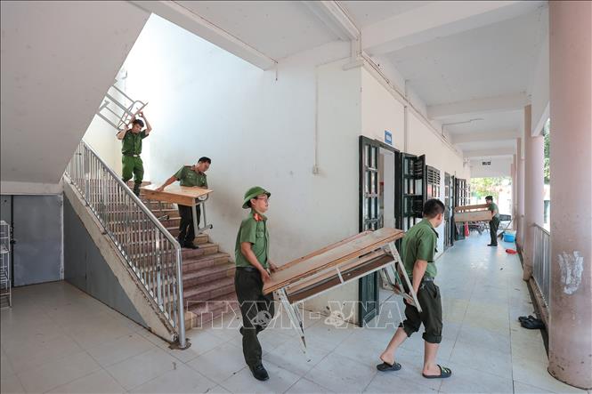 Cán bộ, chiến sĩ Công an Hà Nội vận chuyển bàn ghế giúp nhà trường sau mưa lũ. Anh: Lê Đông - TTXVN