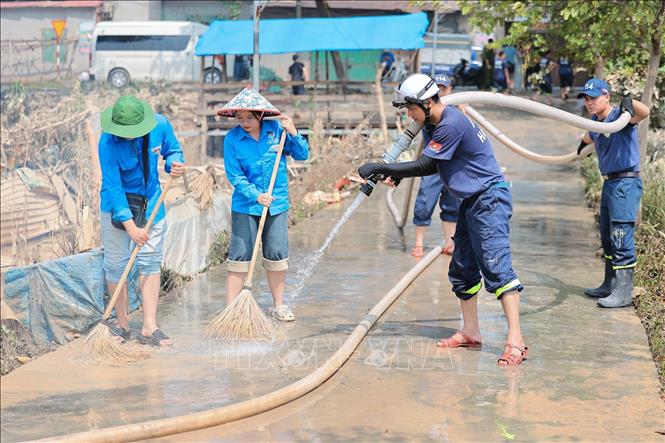 Cảnh sát Phòng cháy chữa cháy Thủ Đô phối hợp với Đoàn thanh niên xã Trung Giã quét rửa bùn đất tại thôn Bình An, xã Trung Giã, Hà Nội. Ảnh: Lê Đông - TTXVN