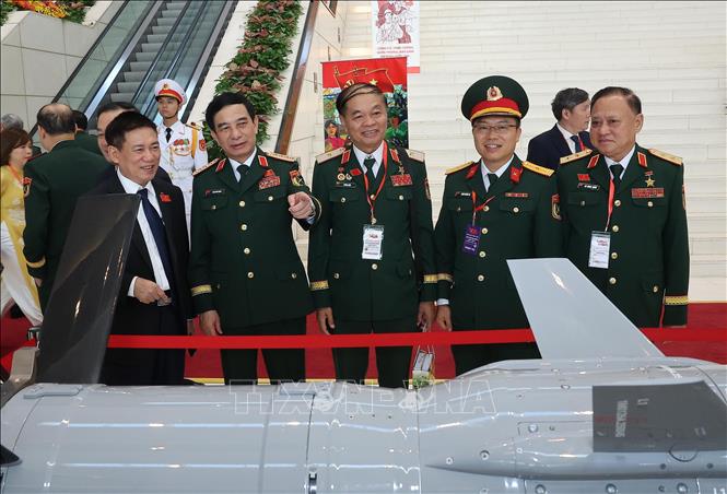 Đại tướng Phan Văn Giang, Uỷ viên Bộ Chính trị, Phó Bí thư Quân ủy Trung ương, Bộ trưởng Bộ Quốc phòng cùng các đại biểu tham quan triển lãm thành tựu phát triển khoa học, công nghệ và đổi mới sáng tạo và chuyển đổi số. Ảnh: TTXVN