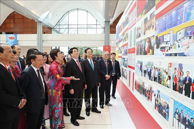 Bí thư Đảng uỷ, Tổng Giám đốc TTXVN Vũ Việt Trang giới thiệu với Chủ tịch nước Lương Cường, nguyên Thủ tướng Nguyễn Tấn Dũng và các đại biểu tham quan triển lãm ảnh về Đại hội. Ảnh: Lâm Khánh - TTXVN