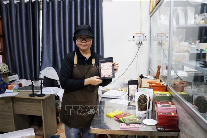 Bà chủ trẻ Lương Thị Duyên giới thiệu 15 loại socola thanh do của Công ty TNHH Bản Cacao của mình sản xuất. Ảnh: Chu Quốc Hùng-TTXVN