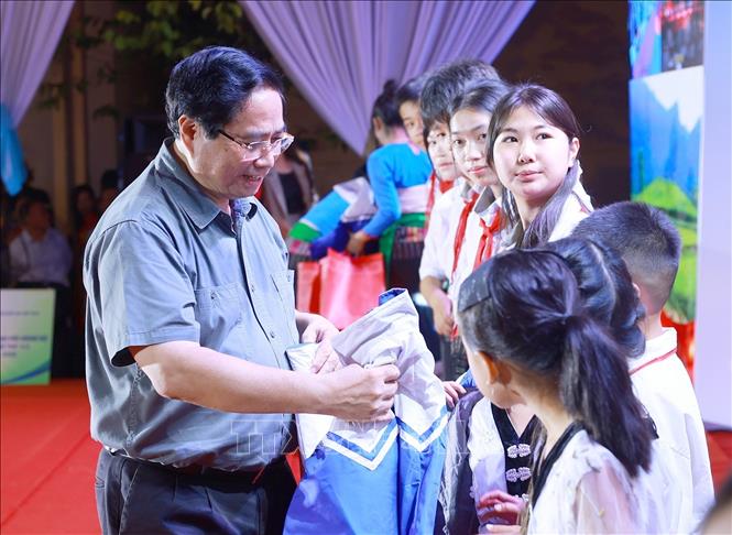 Thủ tướng Phạm Minh Chính tặng áo ấm cho học sinh xã Bát Mọt. Ảnh: Dương Giang-TTXVN 