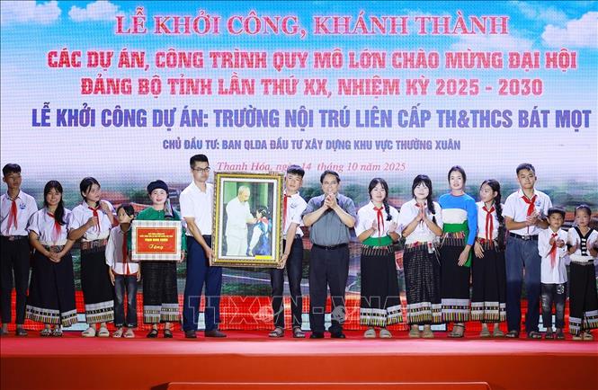 Thủ tướng Phạm Minh Chính tặng bức ảnh Bác Hồ quàng khăn đỏ cho thiếu nhi tặng giao viên và học sinh xã Bát Mọt. Ảnh: Dương Giang-TTXVN 
