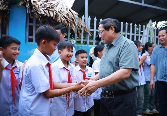 Thủ tướng Phạm Minh Chính với học sinh và đồng bào các dân tộc xã Bát Mọt, tỉnh Thanh Hoá. Ảnh: Dương Giang-TTXVN 
