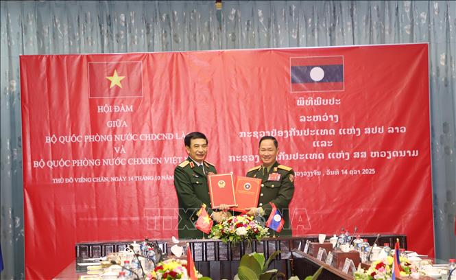 Đại tướng Phan Văn Giang, Bộ trưởng Bộ Quốc phòng Việt Nam và Thượng tướng Khamliang Outhakaysone, Bộ trưởng Bộ Quốc phòng Lào, trao Biên bản ký kết hợp tác giữa Bộ Quốc phòng hai nước. Ảnh: Xuân Tú - PV TTXVN tại Lào