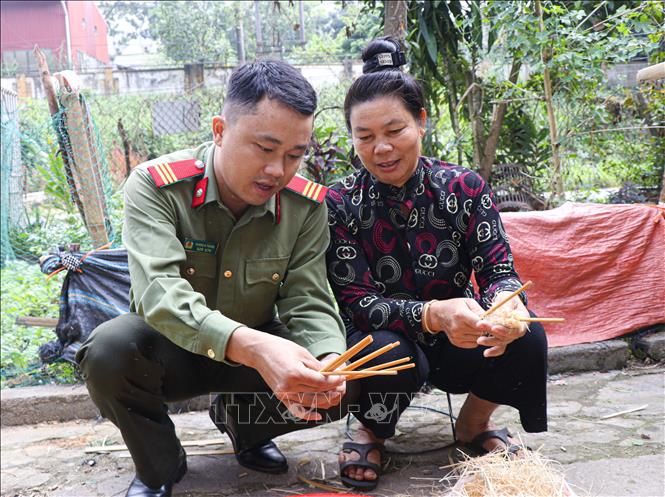 Thượng sĩ Giàng A Thắng hướng dẫn người bệnh vót đũa. Ảnh: Phan Quân - TTXVN