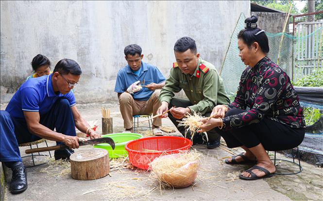 Thượng sĩ Giàng A Thắng hướng dẫn người bệnh tham gia vót đũa. Ảnh: Phan Quân - TTXVN