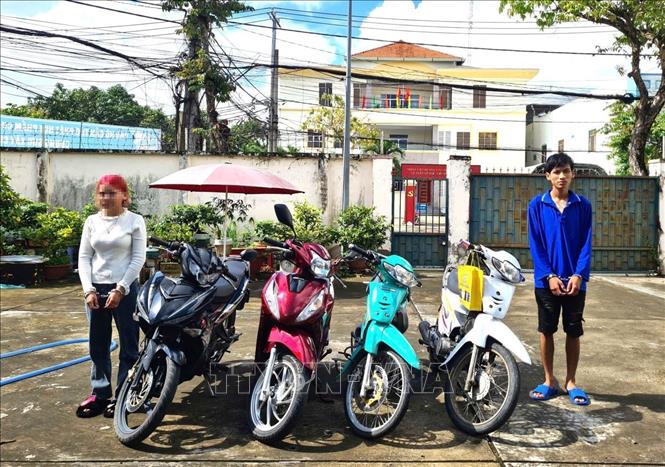 Hai đối tượng Trần Văn Phong và Nguyễn Thị Kim Cát cùng 4 chiếc xe máy trộm được. Ảnh: TTXVN phát