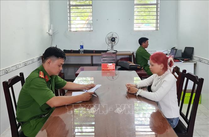 Công an phường Tân An làm việc với đối tượng Nguyễn Thị Kim Cát. Ảnh: TTXVN phát