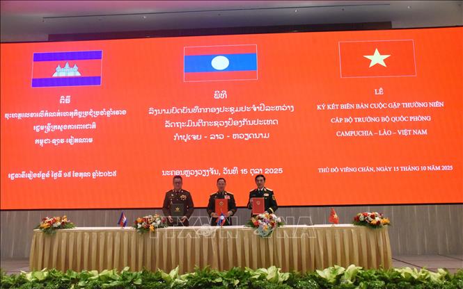 Bộ trưởng Quốc phòng Việt Nam-Lào-Campuchia ký biên bản cuộc gặp. Ảnh: Xuân Tú - PV TTXVN tại Lào