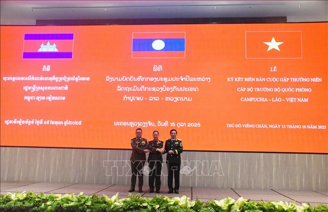 Bộ trưởng Quốc phòng Việt Nam - Lào - Campuchia bắt tay thể hiện tình đoàn kết. Ảnh: Xuân Tú - PV TTXVN tại Lào