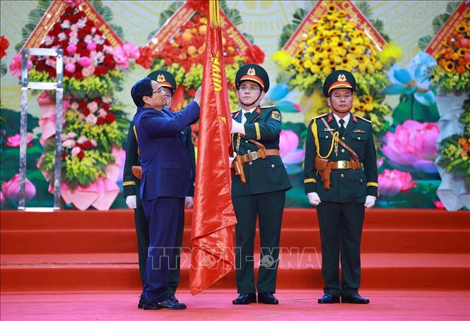 Thủ tướng Phạm Minh Chính gắn Huân chương Hồ Chí Minh lên Cờ truyền thống của Quân khu 5. Ảnh: Dương Giang-TTXVN 