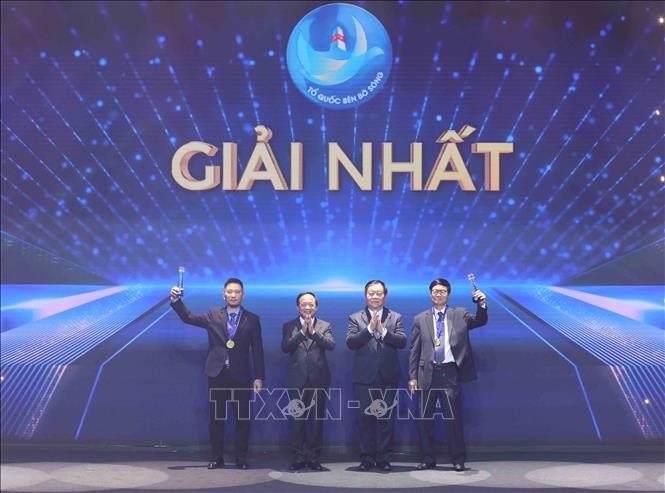 Trưởng Ban Tuyên giáo và Dân vận Trung ương Nguyễn Trọng Nghĩa, Đại tướng Trịnh Văn Quyết, Chủ nhiệm Tổng cục Chính trị Quân đội nhân dân Việt Nam trao giải Nhất cho các tác giả. Ảnh: Phương Hoa - TTXVN