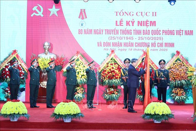 Tổng Bí thư Tô Lâm gắn Huân chương Hồ Chí Minh lên lá cờ truyền thống lực lượng Tình báo Quốc phòng Việt Nam. Ảnh: Thống Nhất - TTXVN