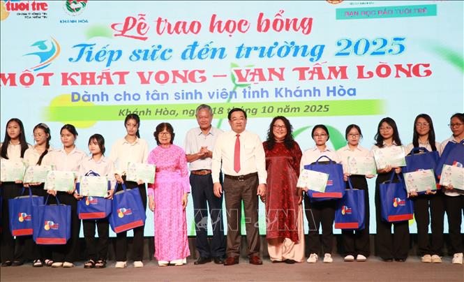 Bà Trần Gia Bảo, Phó Tổng Biên tập Báo Tuổi Trẻ,Ông Trịnh Minh Hoàng, Phó Chủ tịch Ủy ban nhân dân tỉnh Khánh Hòa và các đại biểu trao học bổng cho các tân sinh viên vượt khó. Ảnh: Phan Sáu - TTXVN