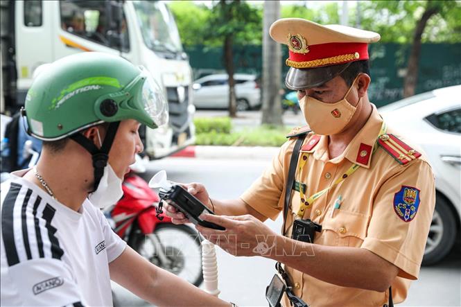  Tổ công tác đội CSGT số 6 kiểm tra nồng độ cồn với người tham gia giao thông tại tuyến đường Lê Đức Thọ. Ảnh: Phạm Kiên - TTXVN