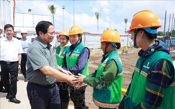 Thủ tướng Phạm Minh Chính với công nhân thi công dự án Khu nhà ở xã hội của thành phố Cần Thơ. Ảnh: Dương Giang-TTXVN 
