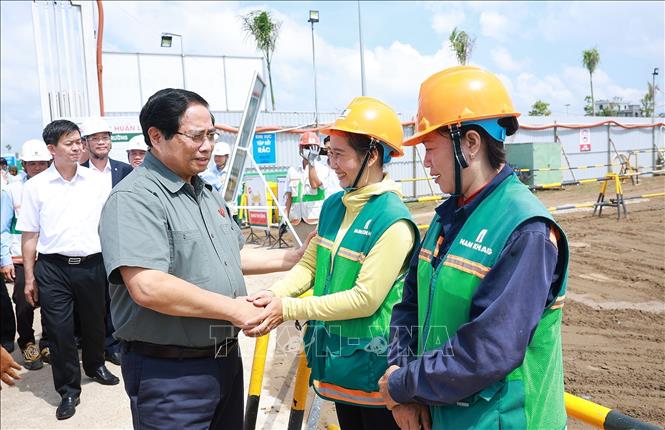 Thủ tướng Phạm Minh Chính với công nhân thi công dự án Khu nhà ở xã hội của thành phố Cần Thơ. Ảnh: Dương Giang-TTXVN 
