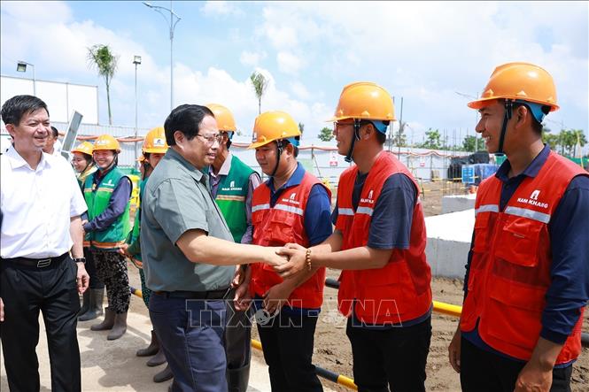 Thủ tướng Phạm Minh Chính với công nhân thi công dự án Khu nhà ở xã hội của thành phố Cần Thơ. Ảnh: Dương Giang-TTXVN 

