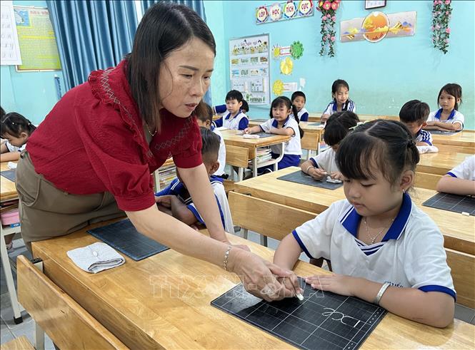 Cô và trò trường Tiểu học Tân Hòa A nắn nót từng nét chữ. Ảnh: Đức Hạnh - TTXVN