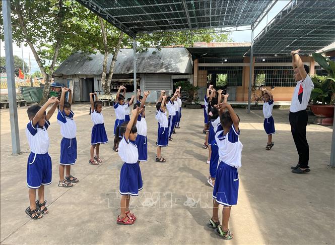 Thầy và trò trong tiết học thể dục tại điểm phụ của trường Trường Tiểu học Tân Hòa A. Ảnh: Đức Hạnh - TTXVN